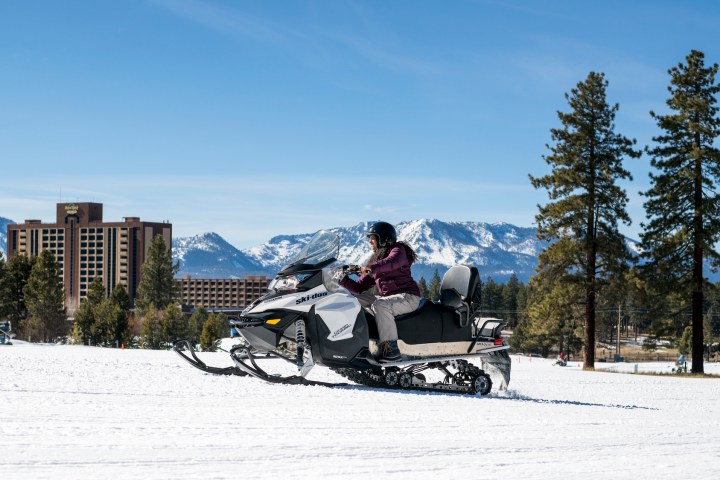 a man riding a snowboard down a snow covered slope