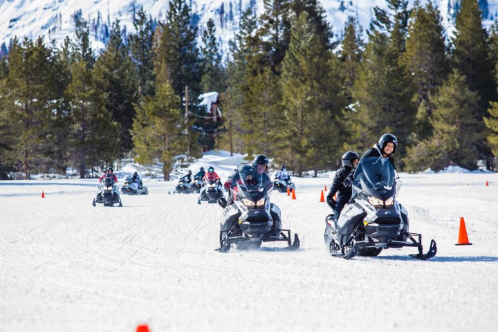 a group of people riding skis on top of a snow covered slope