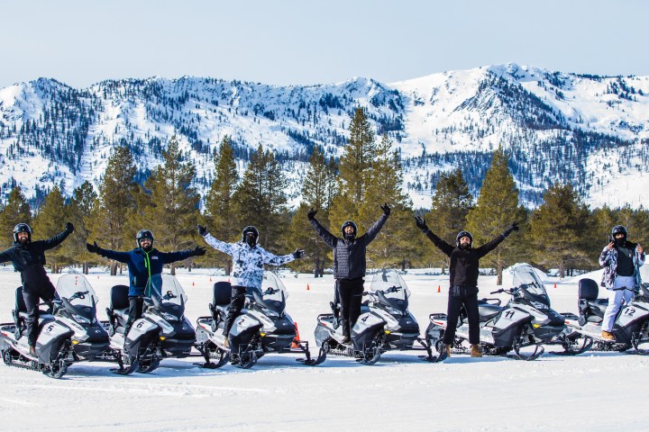 a group of people riding skis on a snowy mountain