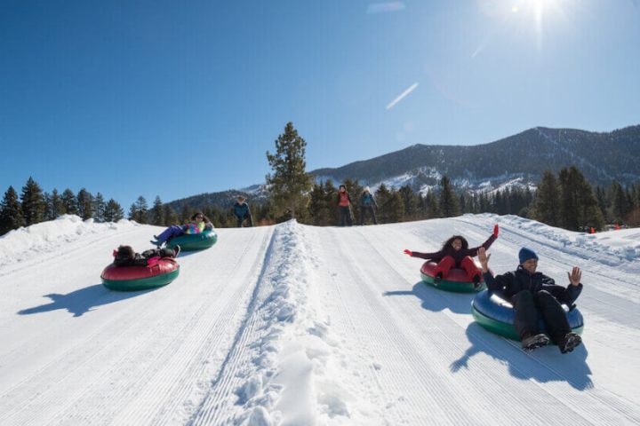 a man riding a snowboard down a snow covered slope