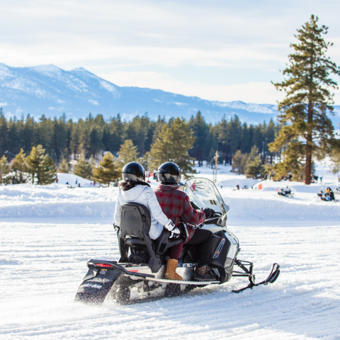 a man sitting on top of a snow covered slope