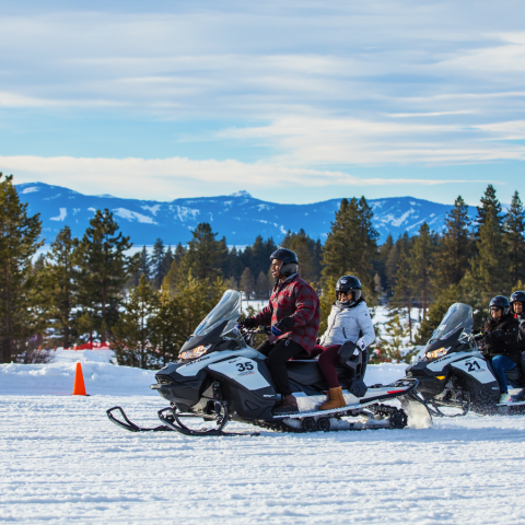 a group of people riding skis on top of a snow covered slope