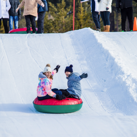 a group of people riding skis down a snow covered slope