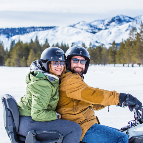 a person sitting on top of a snow covered slope