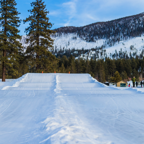 a man riding a snowboard down a snow covered slope