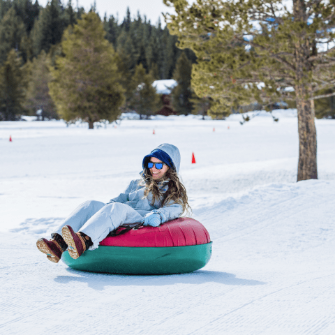 a person riding a snowboard down a snow covered slope