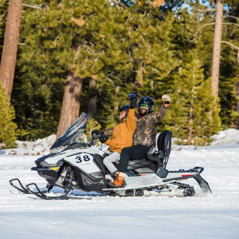 a group of people riding skis across snow covered ground