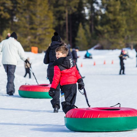 a group of people riding skis across snow covered ground