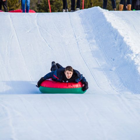 a group of people riding skis down a snow covered slope