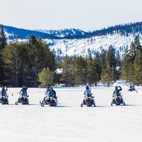 a group of people riding skis on top of a snow covered slope