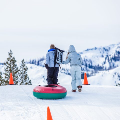 a person riding a snowboard down a snow covered slope