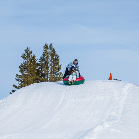a man riding a snowboard down a snow covered slope