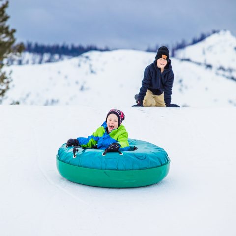 a person riding a snowboard down a snow covered slope
