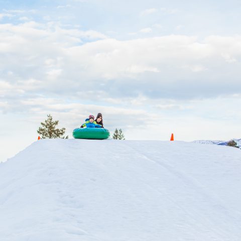 a person riding a snowboard down a snow covered slope