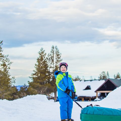 a man riding a snowboard down a snow covered slope
