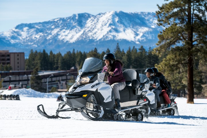 a man riding a motorcycle down a snow covered slope